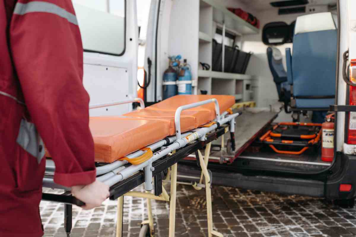 Infermiere spinge la barella in ambulanza