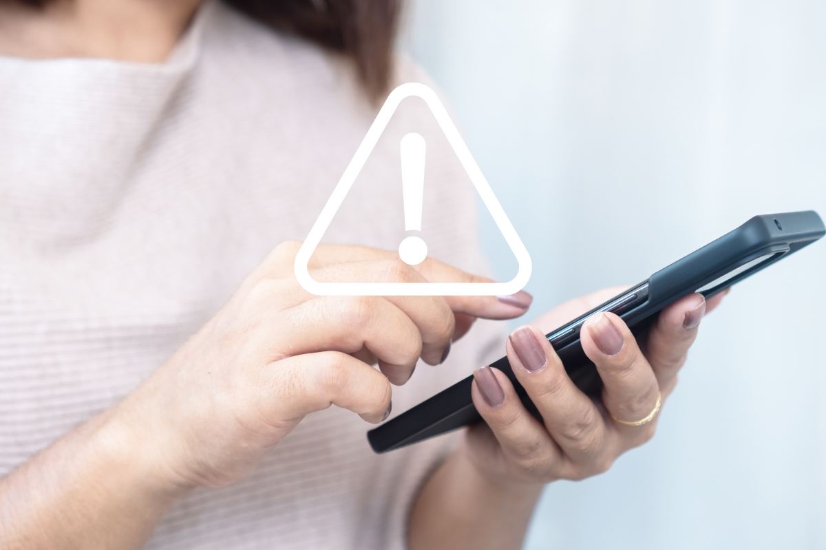 smartphone in mano simbolo pericolo